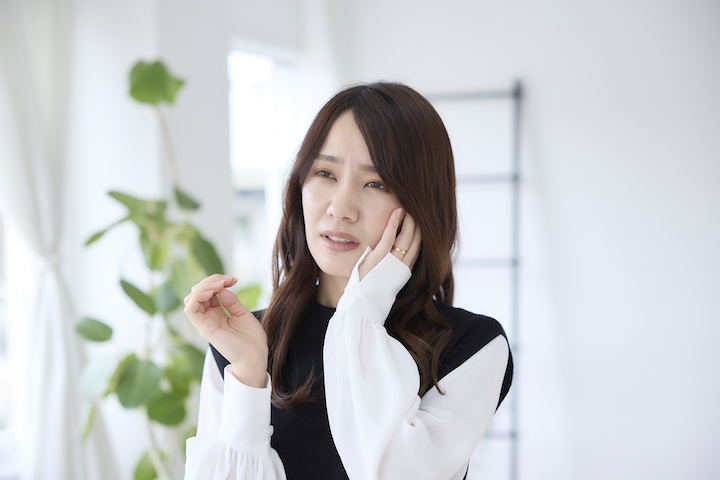 歯が痛くて頬を押さえる女性