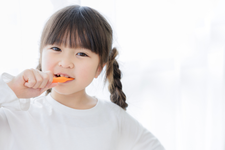 虫歯を予防するために自宅で歯磨きをする子ども