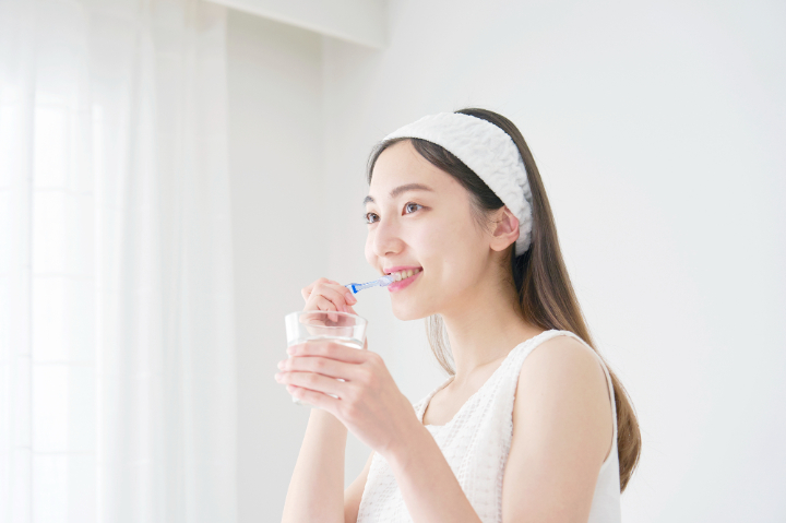 セラミックの歯を長く使い続けるために丁寧な歯磨きをする女性