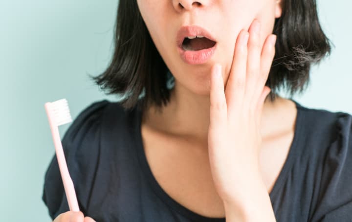 ブラッシング時に出血して驚く女性