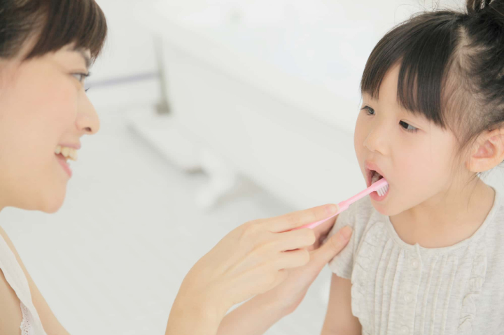 歯肉炎を予防するために仕上げ磨きをする親子