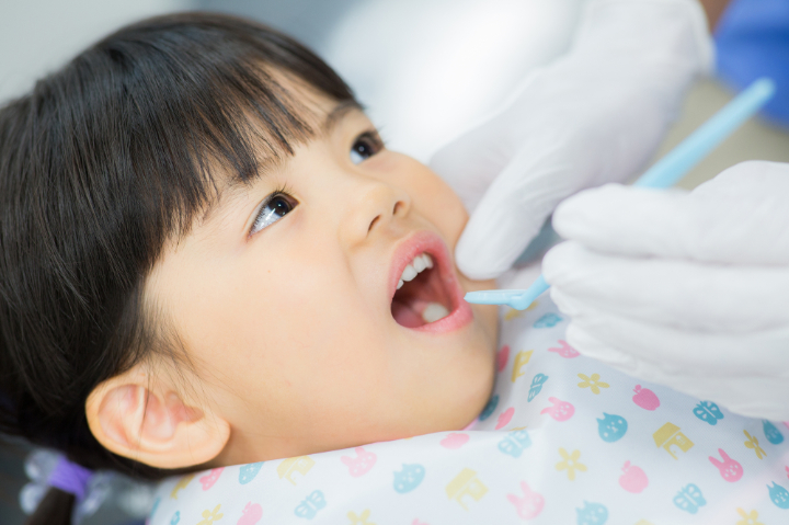 歯科医院でフッ素塗布をしてもらう子ども