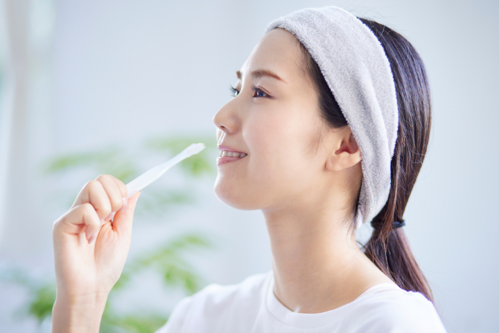 セラミックの歯による口臭を予防するため丁寧に歯磨きをする女性