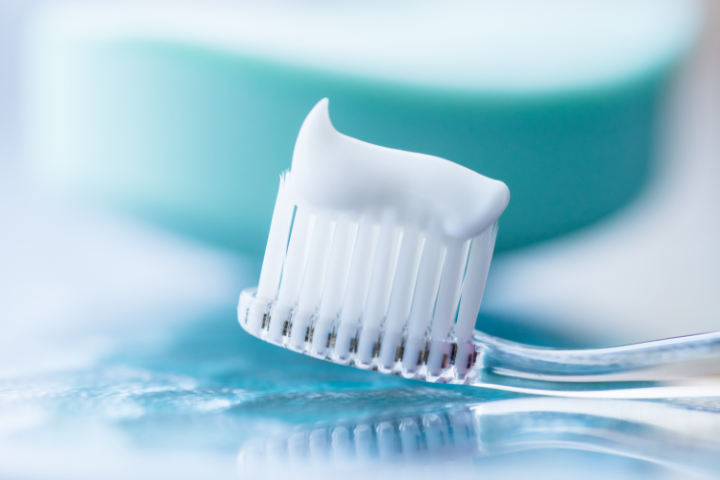 ホワイトニング後に歯がしみるため知覚過敏用の歯磨き粉を使用する様子