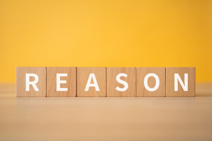 理由と英語で書かれた木製ブロック