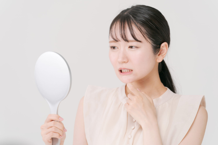 ダイレクトボンディングをした歯を鏡で見て後悔する女性