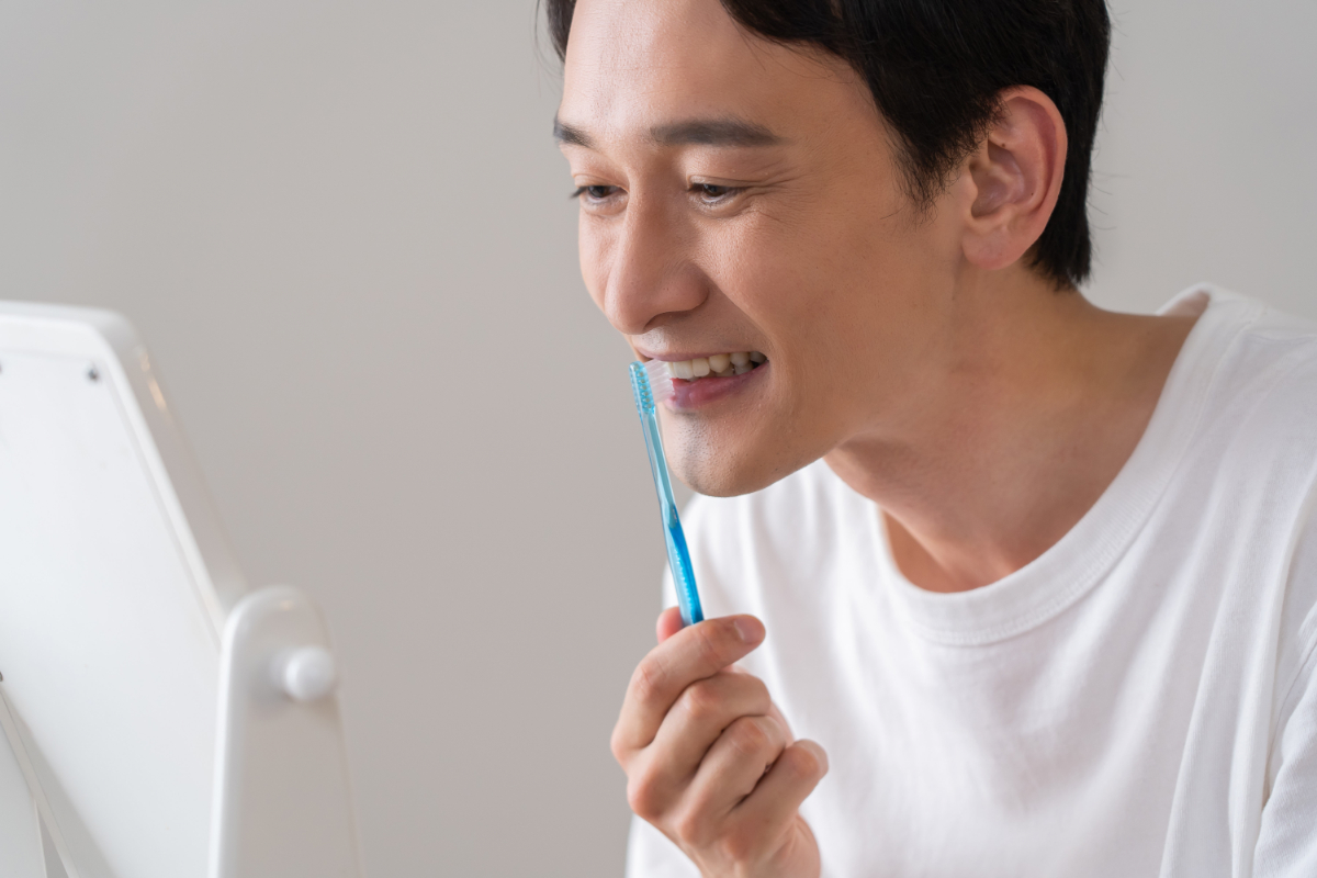 歯の詰め物の変色を防ぐために丁寧に歯磨きしている男性
