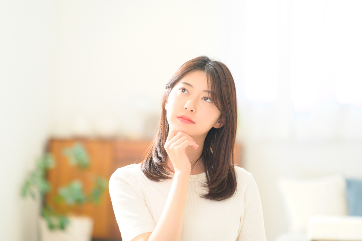 歯周病で歯がぐらつくのはどうしてかを考える女性