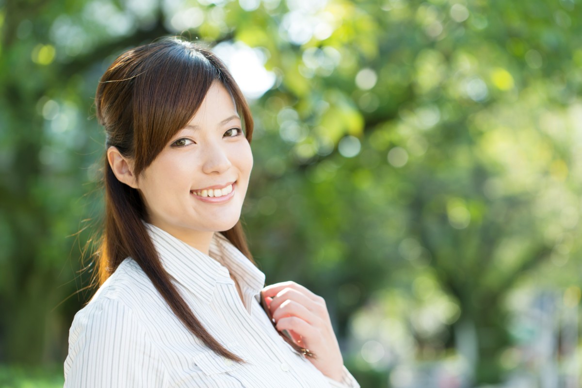 ホワイトニングに満足してほほ笑む女性